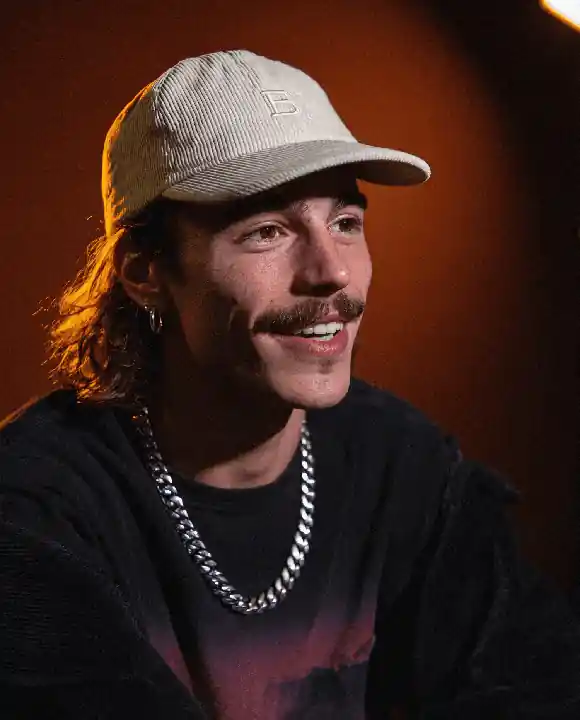 A young man with a beige cap
